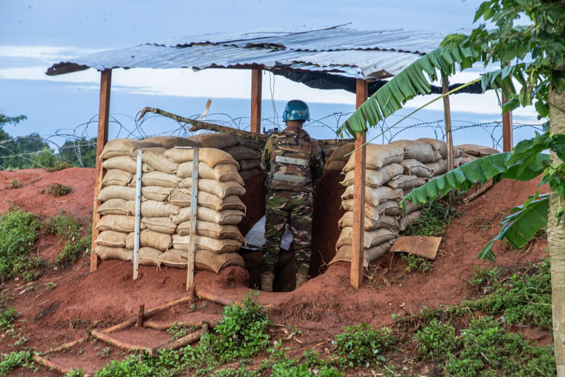 A UN Peacekeeper stands guard at a tower.