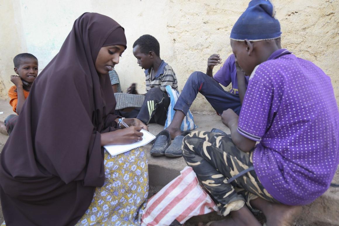 Jamila Haji Mohamed, Chair-lady of the Mis-Hurty Arlaathey organization, takes the contact information of children leaving on the streets of Baidoa, Somalia. Jamila has helped enroll street children in formal schools.